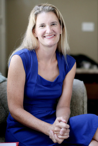 Dr. Jean Twenge seated in a bright blue dress with her hands crossed.